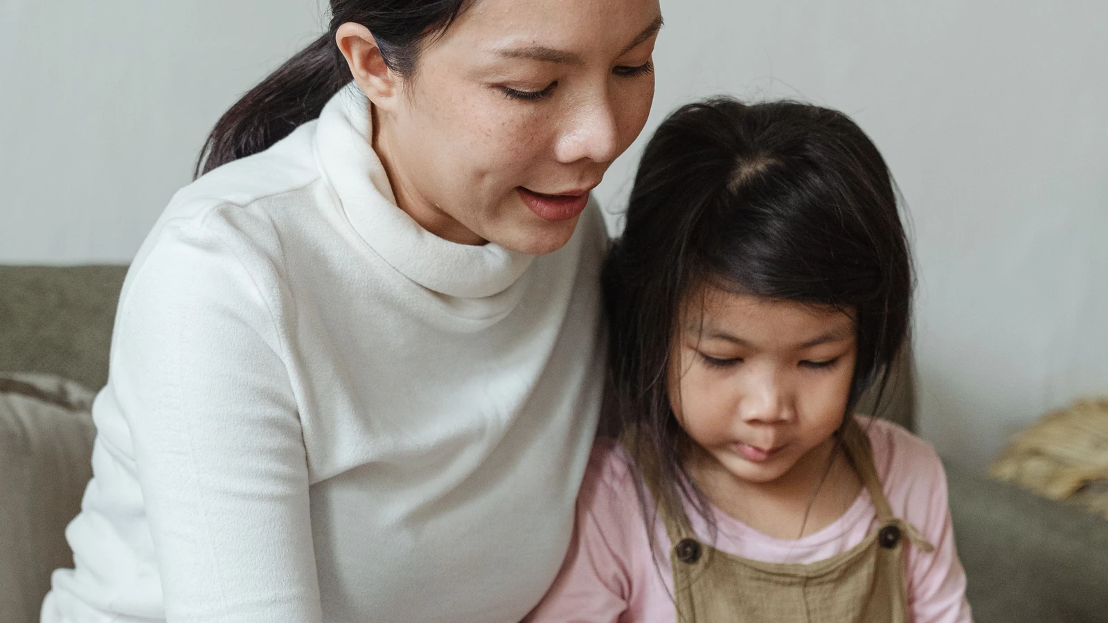 Mother and daughter coloring pictures together at home.