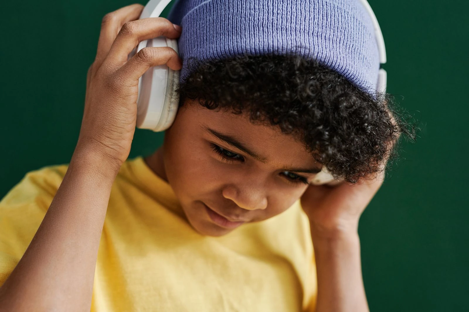 A boy listening calmly through large headphones