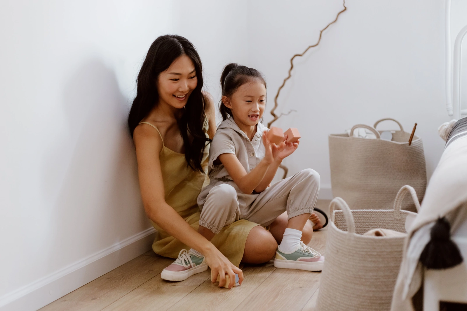 A mother and young daughter playing with wooden building blocks