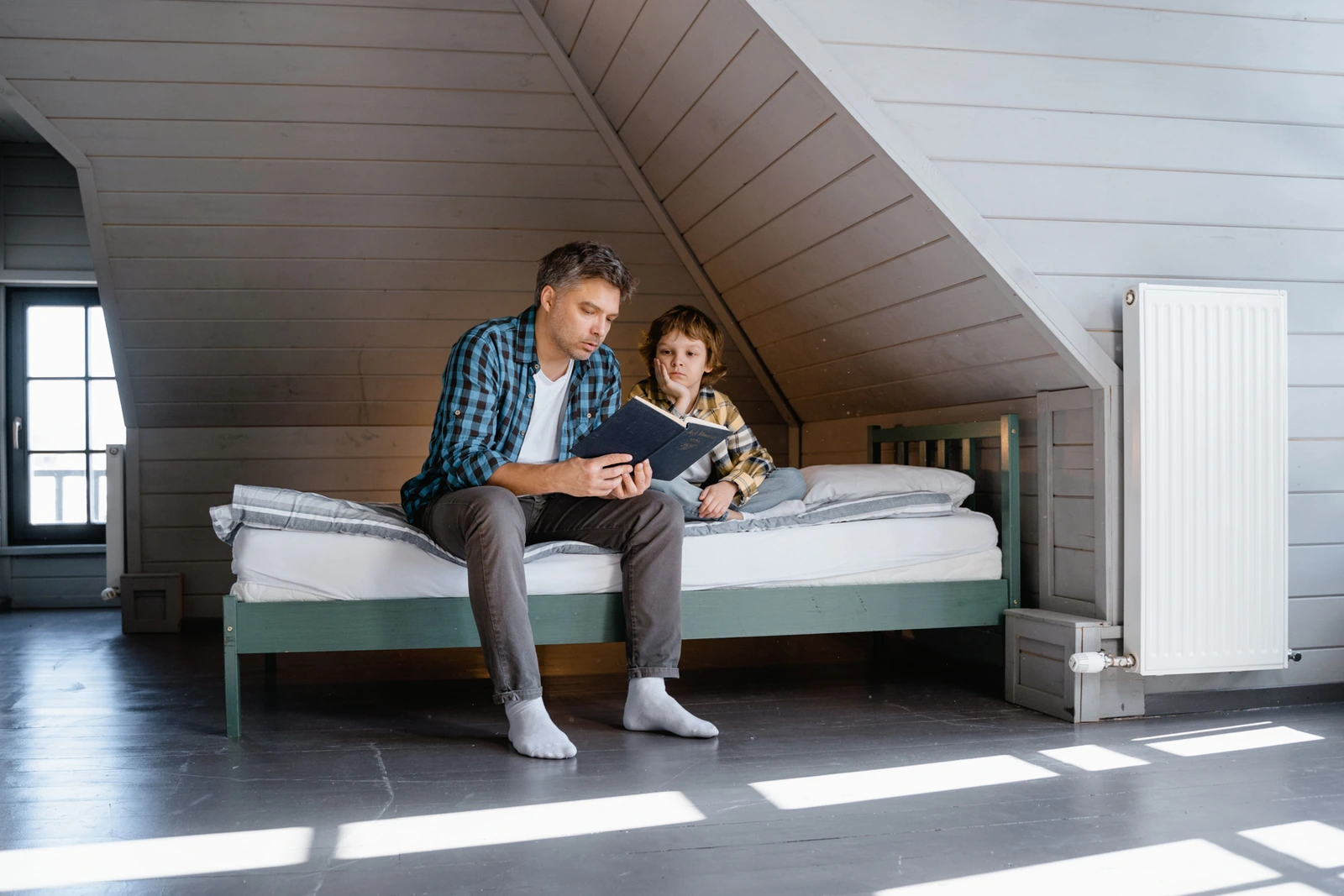 A father and son sharing a book while sitting together at home